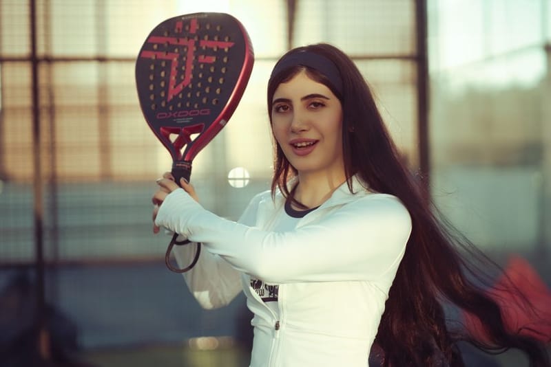 A padel racket resting on a padel court, the kind a tennis player switching to padel would choose