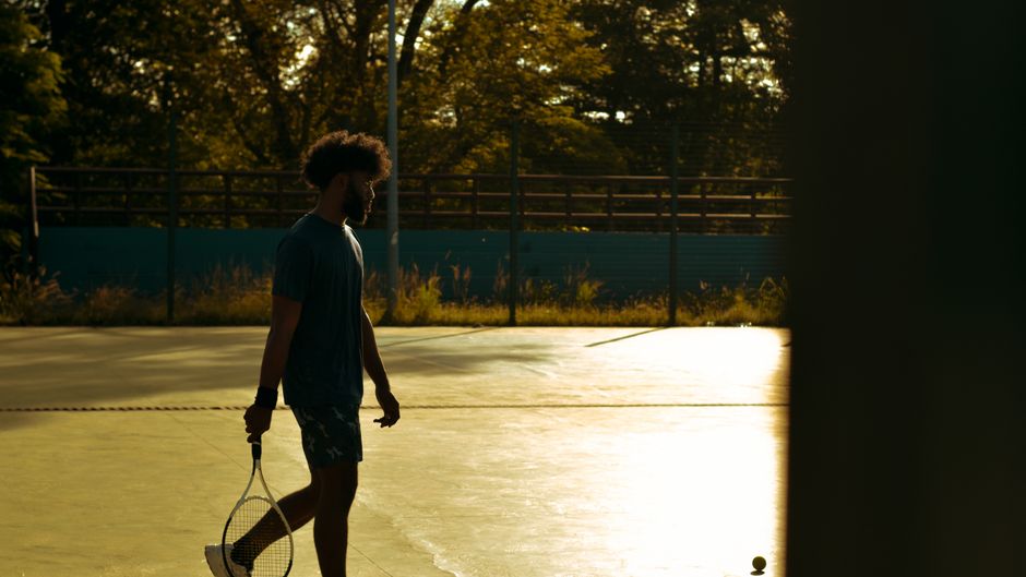Athlete silhouetted on an indoor court